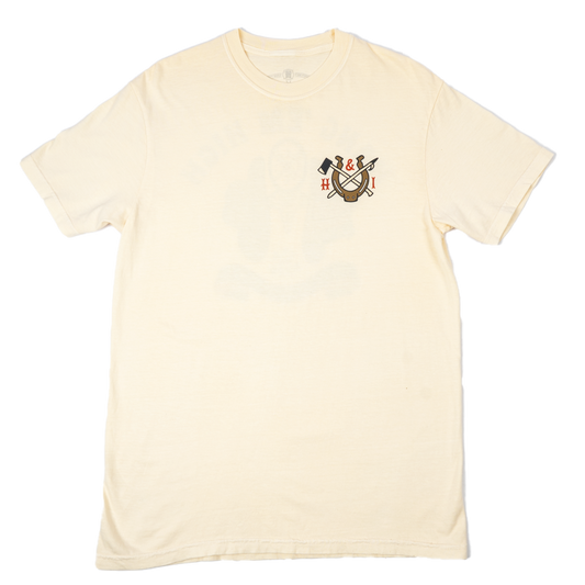 A cream-colored short-sleeve t-shirt with a small screen printed crest on the left chest, displayed flat against a solid white background.