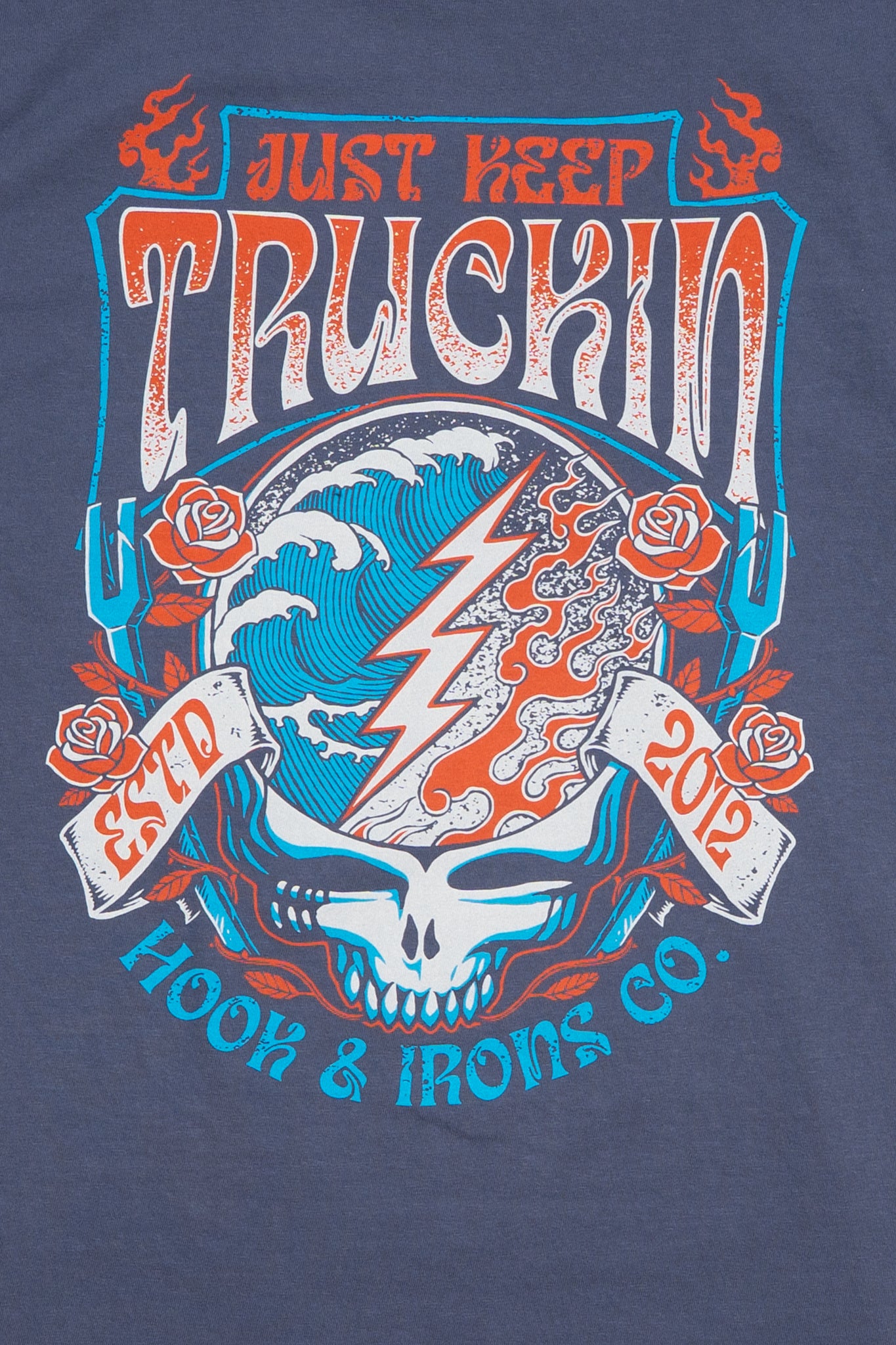 T-shirt with 'Just Keep Truckin' design featuring a skull, lightning bolt, and roses on a blue background.