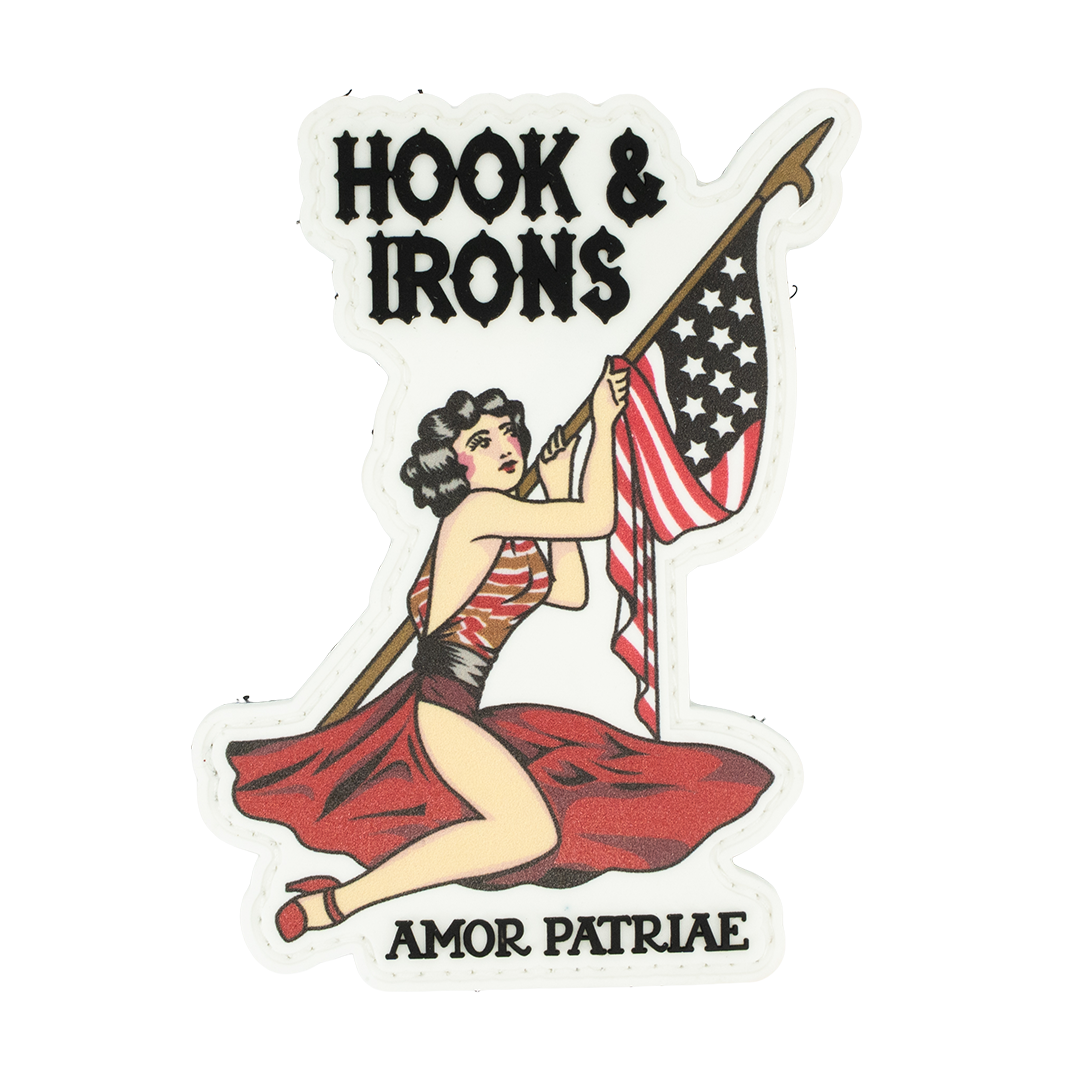 PVC Patch with a woman holding an American flag and spear, text 'Hook & Irons' and 'Amor Patriae', on a white background.