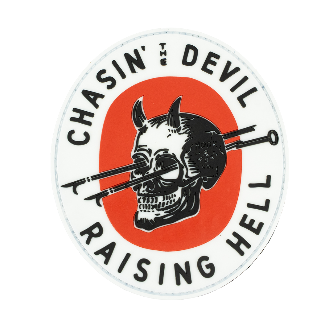 Circular sticker with a skull and crossed hooks design, text 'Chasin' the Devil Raising Hell', on a white background.