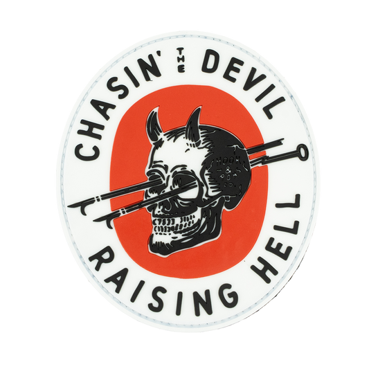 Circular sticker with a skull and crossed hooks design, text 'Chasin' the Devil Raising Hell', on a white background.