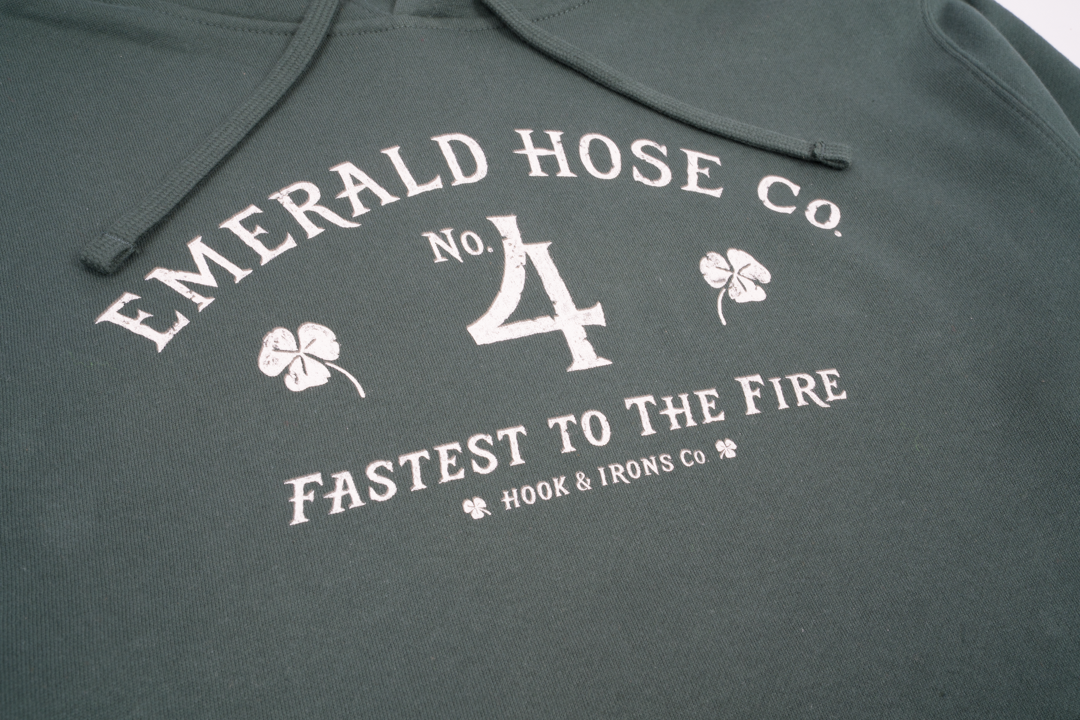 Green hoodie with white text and clover designs on a plain background