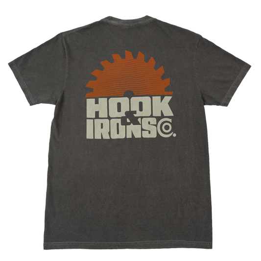 A dark gray heathered t-shirt shown from the back, featuring a large graphic print of an orange circular saw blade and the text 'HOOK IRONS CO.' in a distressed off-white font.