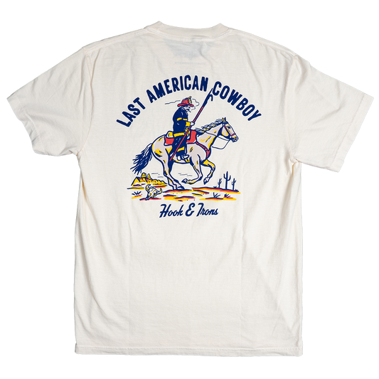 White t-shirt with a graphic of a cowboy on a horse and text 'Last American Cowboy' and 'Hook & Alberts'.